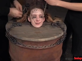 Brunette babe gets dominated in a barrel bondage scene