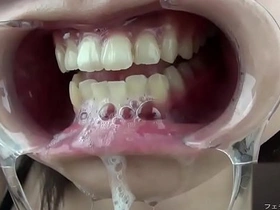 A Japanese woman displays her gums and salivates for a fetish audience